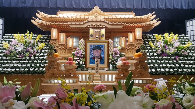 祭壇の写真です、遺影写真の桜や祭壇の花々が色鮮やかです。